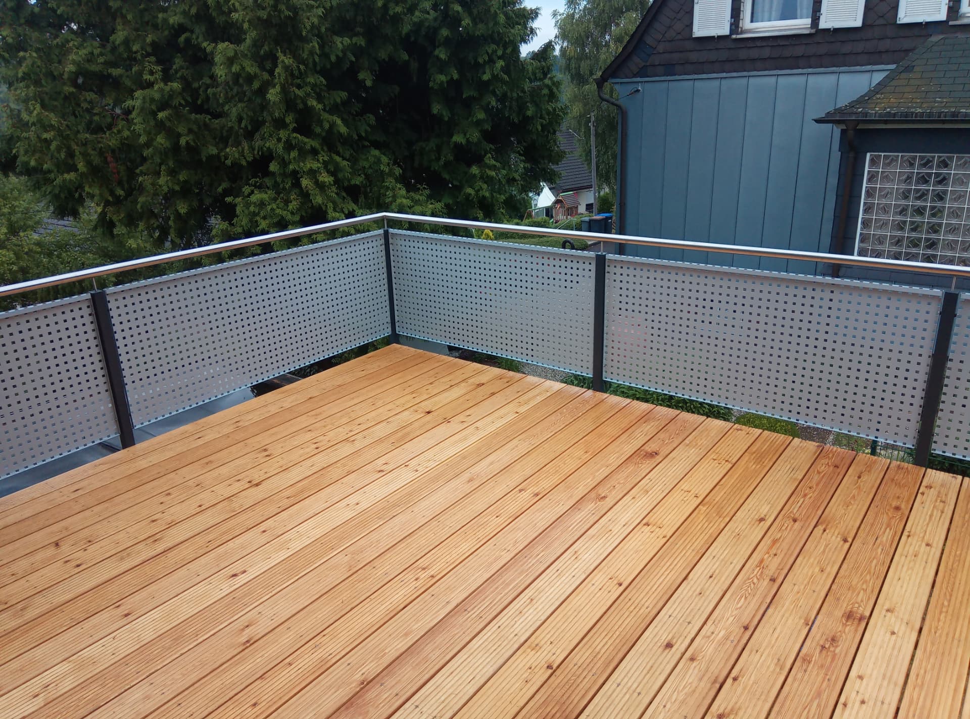 Dachterrasse mit Holzdielen und Lochblechgeländer