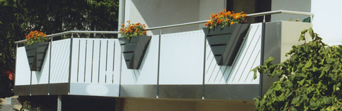 Weißes Balkongeländer mit Blumenkästen an einer Fassade